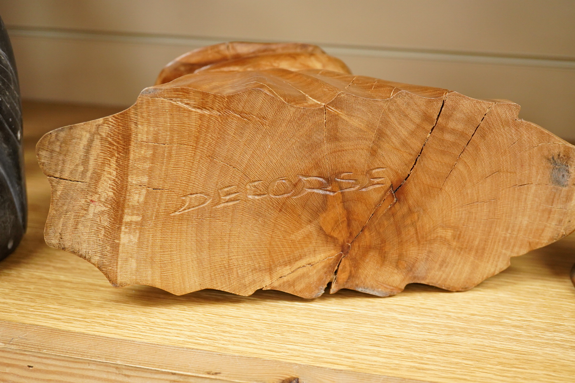 Pierre Decorse (b.1953), a naturalistically modelled wooden sculpture depicting a crouched figure obscured by a large hat 25cm high